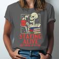 Staying Alive One Book At A Time Skeleton Reading Librarian Unisex Jersey T-Shirt
