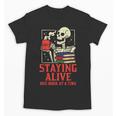 Staying Alive One Book At A Time Skeleton Reading Librarian Unisex T-Shirt