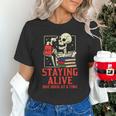Staying Alive One Book At A Time Skeleton Reading Librarian Unisex T-Shirt
