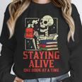 Staying Alive One Book At A Time Skeleton Reading Librarian Unisex Sweatshirt Staying Alive One Book At A Time Skeleton Reading Librarian Unisex Sweatshirt