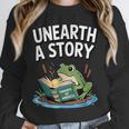 Unearth a Story Frog Reading a Book Summer 2026 Unisex Sweatshirt Unearth a Story Frog Reading a Book Summer 2026 Unisex Sweatshirt