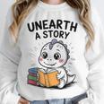 Unearth a Story Cute Dinosaur Summer Reading 2026 Dino Book Unisex Sweatshirt Unearth a Story Cute Dinosaur Summer Reading 2026 Dino Book Unisex Sweatshirt