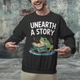 Unearth a Story Frog Reading a Book Summer 2026 Unisex Sweatshirt Unearth a Story Frog Reading a Book Summer 2026 Unisex Sweatshirt