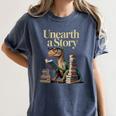 Unearth A Story Dinosaur Reading a Library Book Women's Comfort Colors T-Shirt Moss