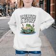 Unearth a Story Frog Reading a Book Summer 2026 Premium Tri-Blend Youth Crewneck Sweatshirt Unearth a Story Frog Reading a Book Summer 2026 Premium Tri-Blend Youth Crewneck Sweatshirt