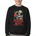 Staying Alive One Book At A Time Skeleton Reading Librarian Youth Crewneck Sweatshirt Staying Alive One Book At A Time Skeleton Reading Librarian Youth Crewneck Sweatshirt