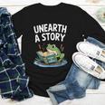 Unearth a Story Frog Reading a Book Summer 2026 Youth Long Sleeve Tee Unearth a Story Frog Reading a Book Summer 2026 Youth Long Sleeve Tee