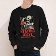 Staying Alive One Book At A Time Skeleton Reading Librarian Youth Long Sleeve Tee