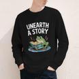 Unearth a Story Frog Reading a Book Summer 2026 Youth Long Sleeve Tee Unearth a Story Frog Reading a Book Summer 2026 Youth Long Sleeve Tee