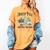 Holiday Scene Nostalgia North Pole Tree Farm Merry Christmas Women's Comfort Colors T-Shirt Mustard Holiday Scene Nostalgia North Pole Tree Farm Merry Christmas Women's Comfort Colors T-Shirt Mustard