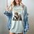 Unearth A Story Dinosaur Reading a Library Book Women's Comfort Colors T-Shirt Denim