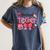 HUGvyn One Loved Teacher Valentine Book Heart Reading Bow Women's Comfort Colors T-Shirt Moss