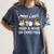 Most Likely To Read A Book On Christmas Snowman Family Women's Comfort Colors T-Shirt Moss