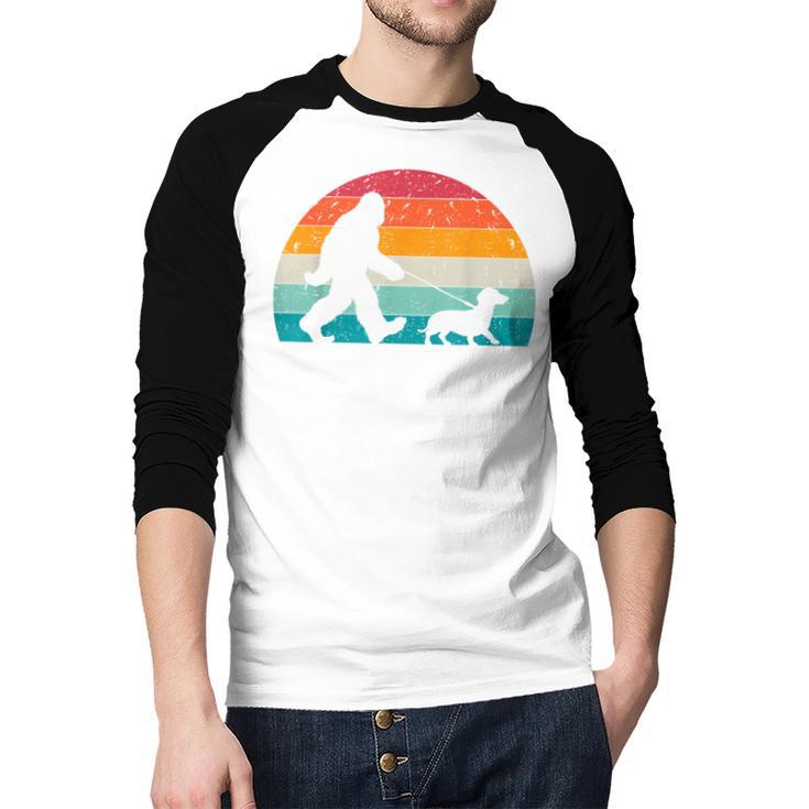Retro Sasquatch Lover Doxie Wiener Dog Walker Bigfoot Walking a Dog Dachshund Weiner Dog Dad Weenie Small Men Baseball Raglan Shirt