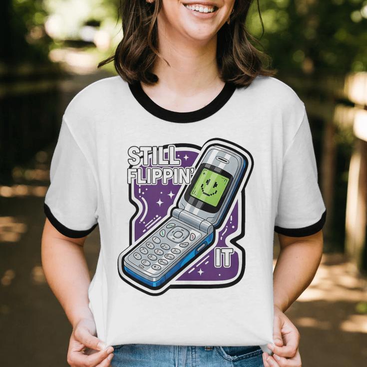 Still Flippin' It Retro Flip Phone 90s Y2K Nostalgia Unisex Cotton Ringer T-Shirt Still Flippin' It Retro Flip Phone 90s Y2K Nostalgia Unisex Cotton Ringer T-Shirt