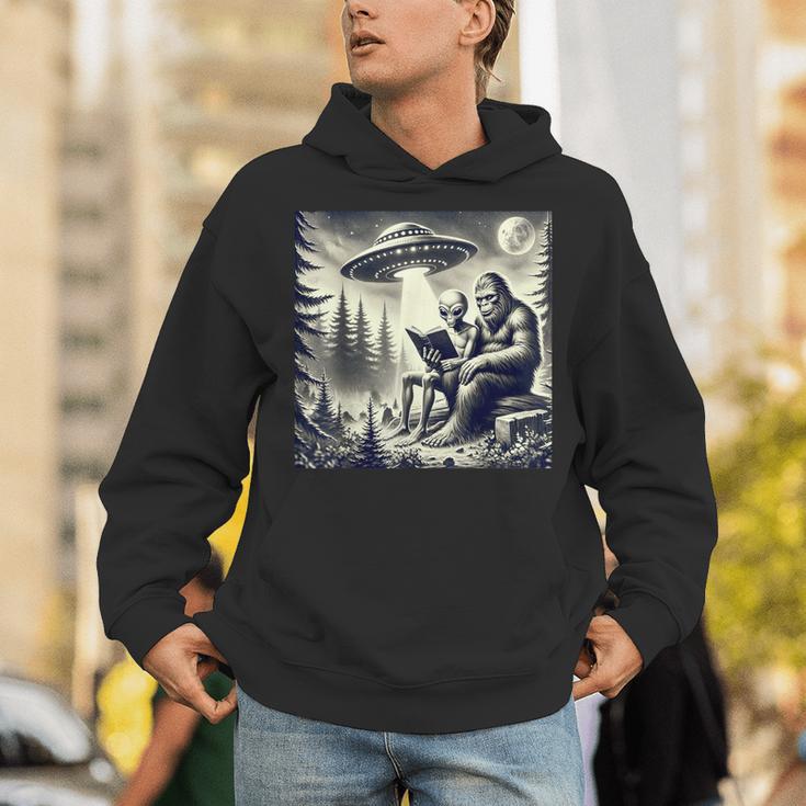 Bigfoot With Alien Reading A Book Bigfoot And UFO Unisex Hoodie