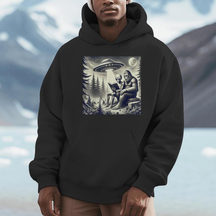 Bigfoot With Alien Reading A Book Bigfoot And UFO Unisex Hoodie