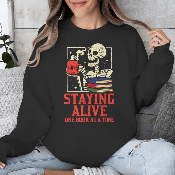 Staying Alive One Book At A Time Skeleton Reading Librarian Unisex Sweatshirt Staying Alive One Book At A Time Skeleton Reading Librarian Unisex Sweatshirt