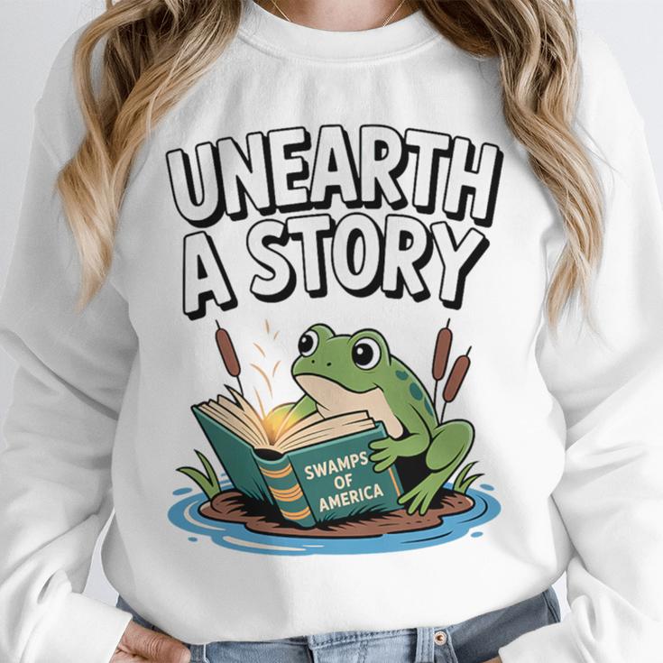Unearth a Story Frog Reading a Book Summer 2026 Premium Tri-Blend Unisex Sweatshirt Unearth a Story Frog Reading a Book Summer 2026 Premium Tri-Blend Unisex Sweatshirt