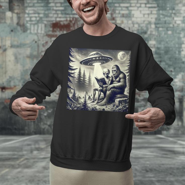 Bigfoot With Alien Reading A Book Bigfoot And UFO Unisex Sweatshirt