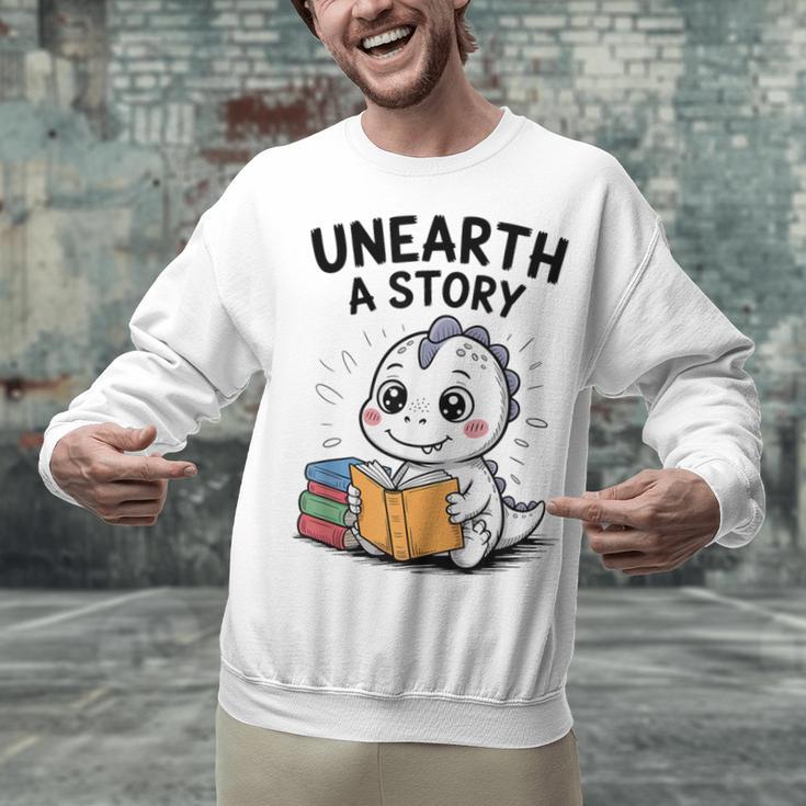 Unearth a Story Cute Dinosaur Summer Reading 2026 Dino Book Unisex Sweatshirt Unearth a Story Cute Dinosaur Summer Reading 2026 Dino Book Unisex Sweatshirt