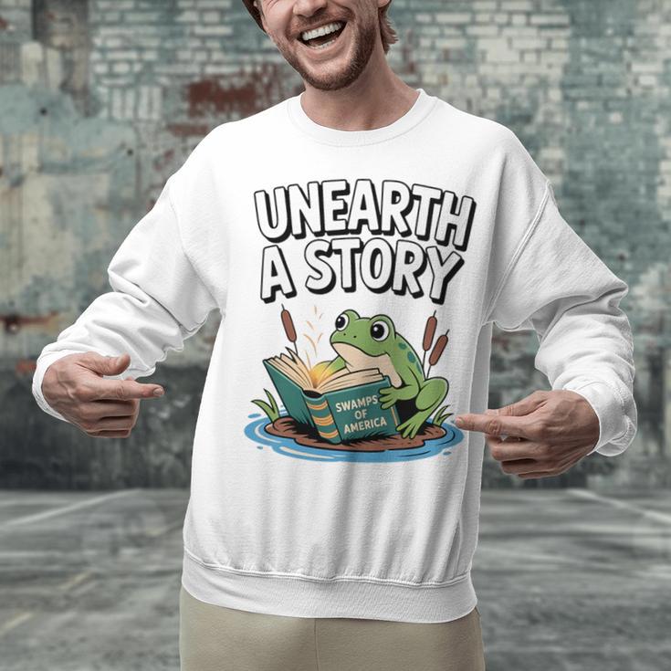 Unearth a Story Frog Reading a Book Summer 2026 Premium Tri-Blend Unisex Sweatshirt Unearth a Story Frog Reading a Book Summer 2026 Premium Tri-Blend Unisex Sweatshirt