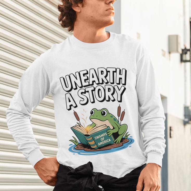 Unearth a Story Frog Reading a Book Summer 2026 Premium Tri-Blend Unisex Long Sleeve T-Shirt Unearth a Story Frog Reading a Book Summer 2026 Premium Tri-Blend Unisex Long Sleeve T-Shirt