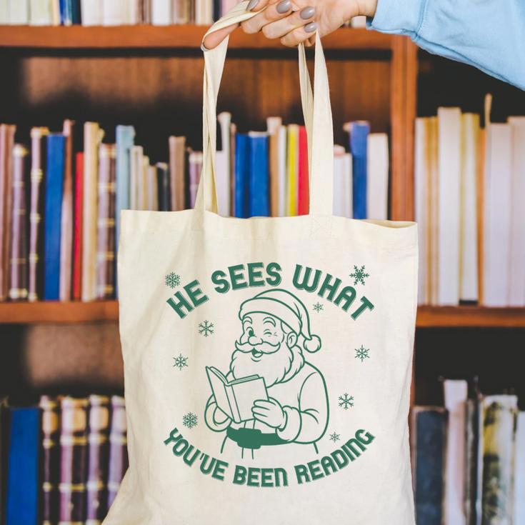 He Sees What You'Ve Been Reading Christmas Bookish Santa Premium Tri-Blend Canvas Tote Bag