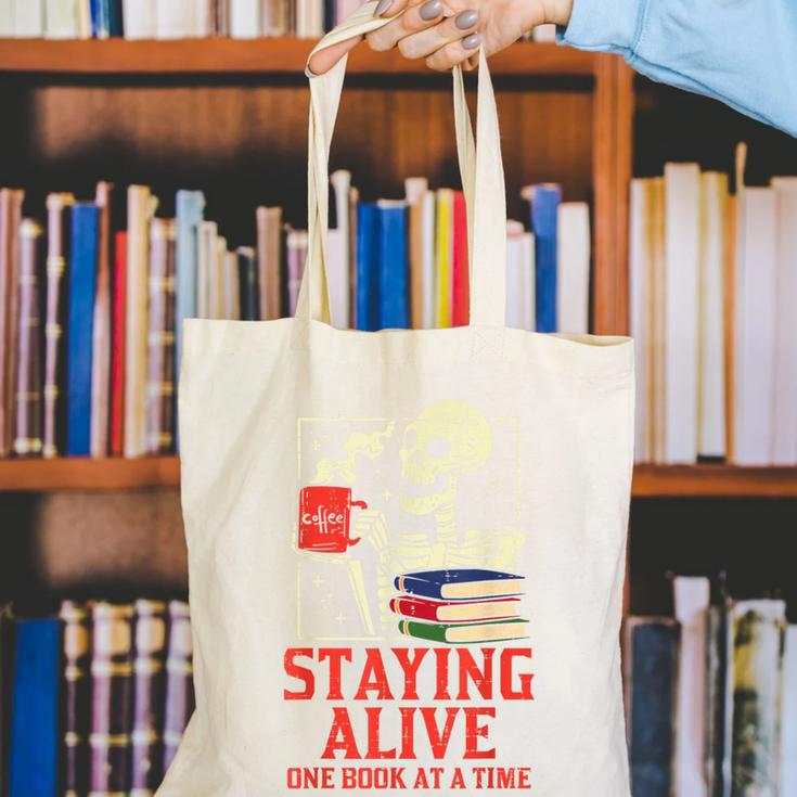 Staying Alive One Book At A Time Skeleton Reading Librarian Canvas Tote Bag Staying Alive One Book At A Time Skeleton Reading Librarian Canvas Tote Bag