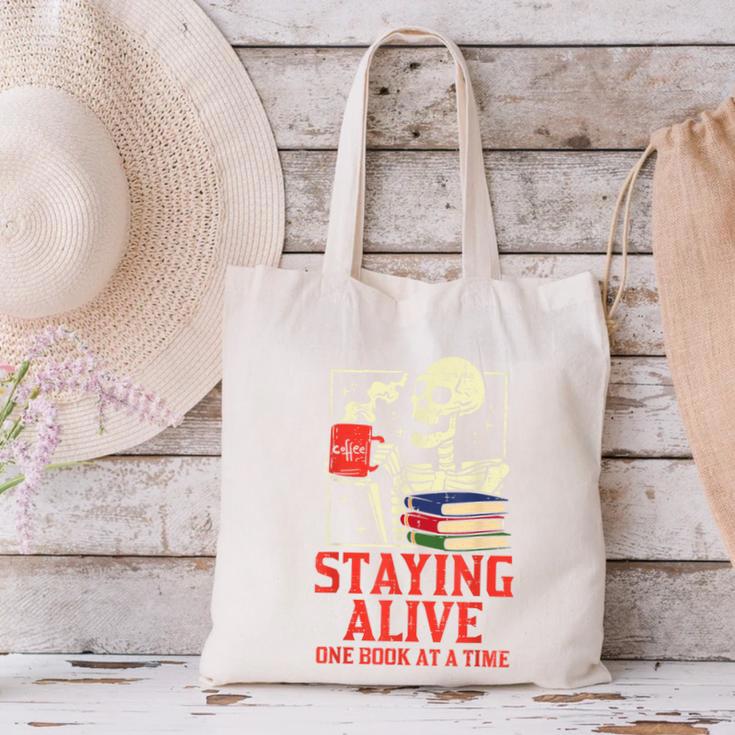 Staying Alive One Book At A Time Skeleton Reading Librarian Canvas Tote Bag Staying Alive One Book At A Time Skeleton Reading Librarian Canvas Tote Bag
