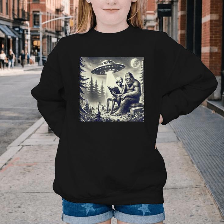 Bigfoot With Alien Reading A Book Bigfoot And UFO Youth Crewneck Sweatshirt
