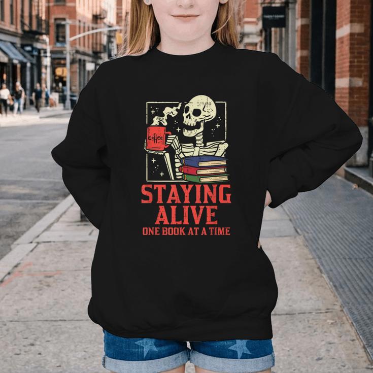 Staying Alive One Book At A Time Skeleton Reading Librarian Youth Crewneck Sweatshirt