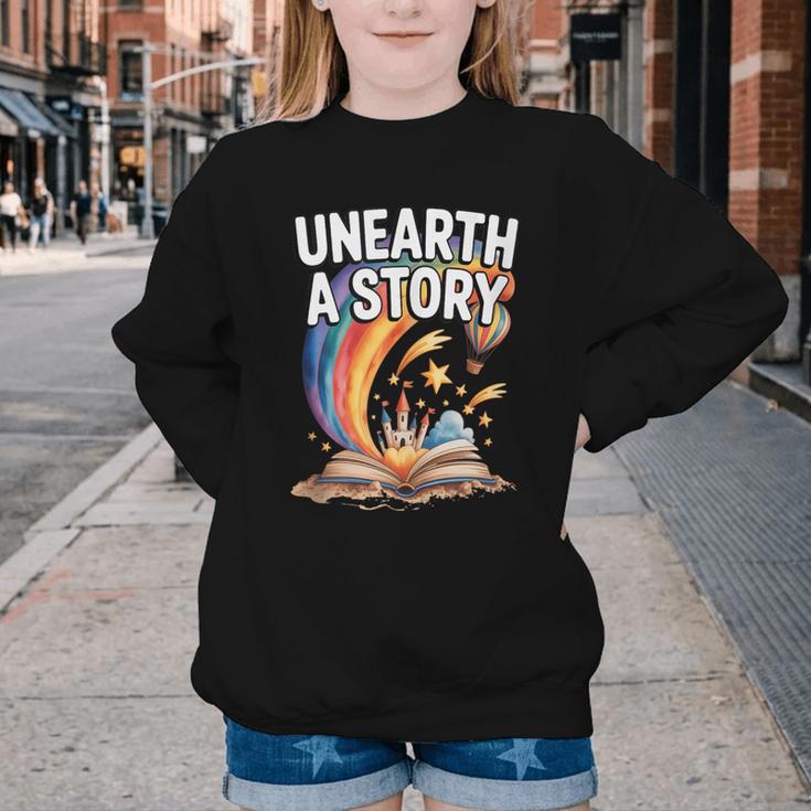 Unearth A Story Rainbow Treasure Book Youth Crewneck Sweatshirt Unearth A Story Rainbow Treasure Book Youth Crewneck Sweatshirt