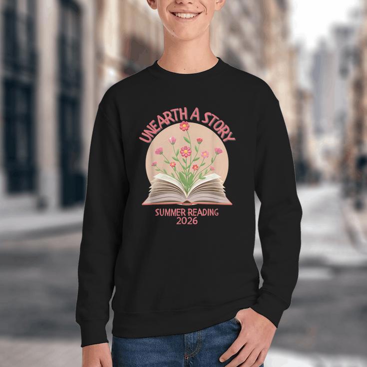 Unearth a Story 2026 Summer Reading Program Flowers Book Youth Crewneck Sweatshirt Unearth a Story 2026 Summer Reading Program Flowers Book Youth Crewneck Sweatshirt