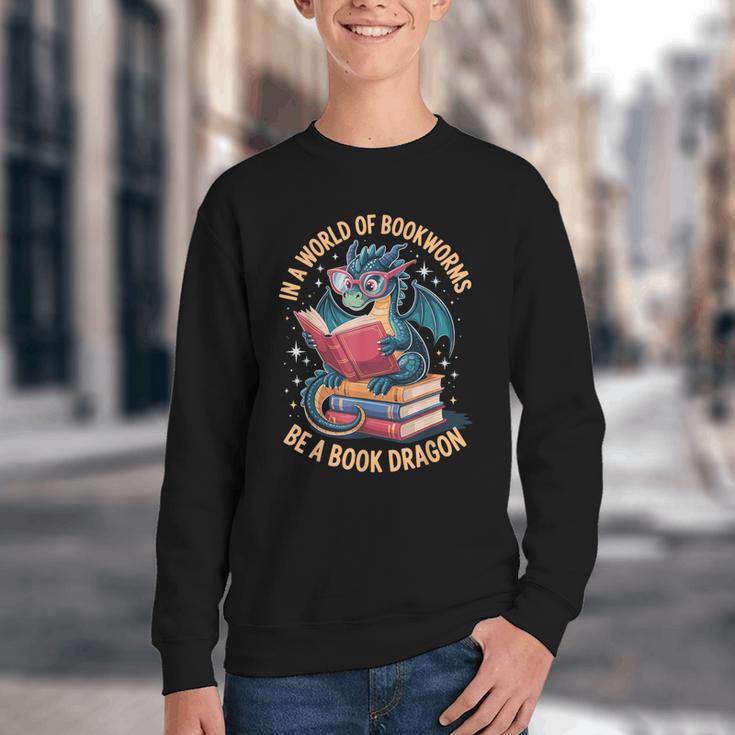 In A World Of Bookworms Be A Book Dragon Youth Crewneck Sweatshirt In A World Of Bookworms Be A Book Dragon Youth Crewneck Sweatshirt