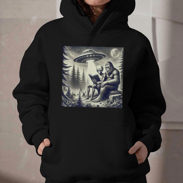 Bigfoot With Alien Reading A Book Bigfoot And UFO Graphic Youth Hoodie