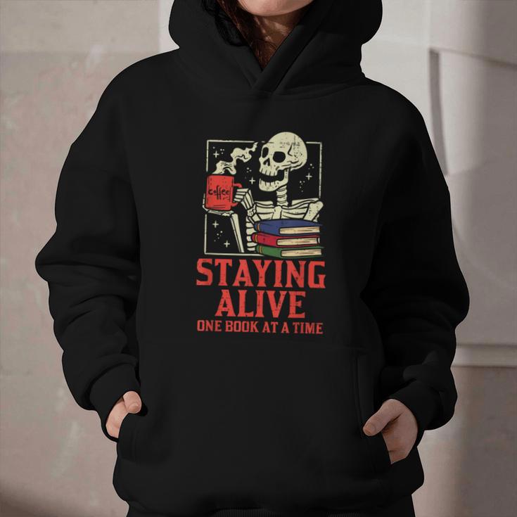 Staying Alive One Book At A Time Skeleton Reading Librarian Graphic Youth Hoodie