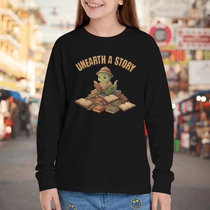 Unearth a Story Dinosaur Reading Books Summer 2026 Youth Long Sleeve Tee