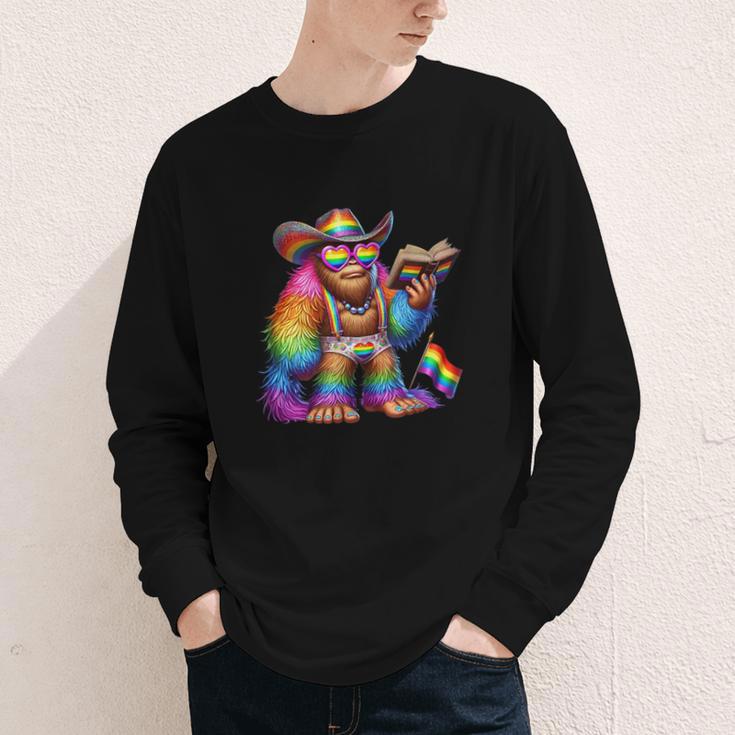 Rainbow Pride Bigfoot Reading Book With Heart Glasses Youth Long Sleeve Tee Rainbow Pride Bigfoot Reading Book With Heart Glasses Youth Long Sleeve Tee