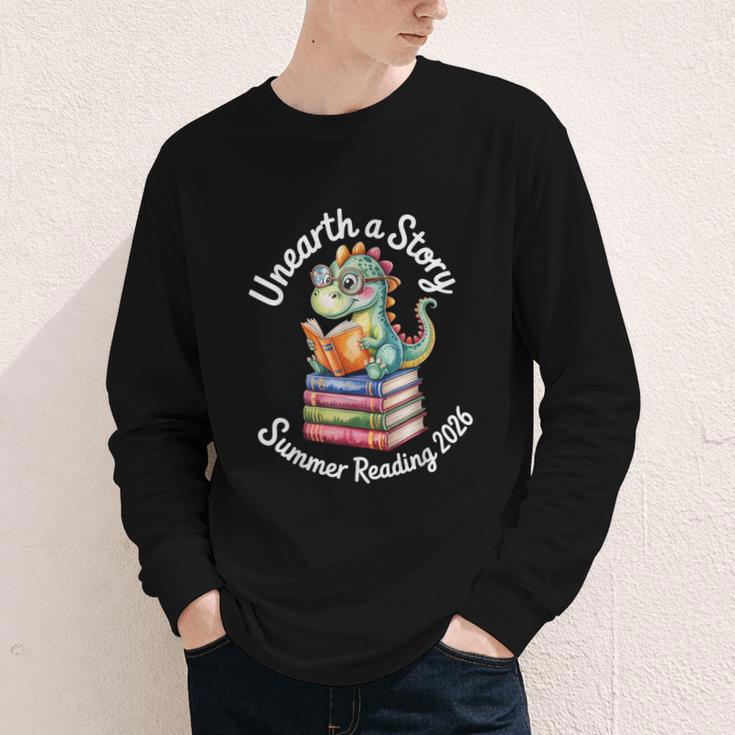 Unearth a Story Summer Reading 2026 Book Lover Dino Fun Youth Long Sleeve Tee