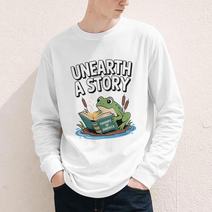 Unearth a Story Frog Reading a Book Summer 2026 Premium Tri-Blend Youth Long Sleeve Tee Unearth a Story Frog Reading a Book Summer 2026 Premium Tri-Blend Youth Long Sleeve Tee